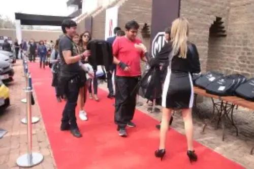 This picture shows the entrance to a product launch event, where a hostesse is handing over some goodie-bags.