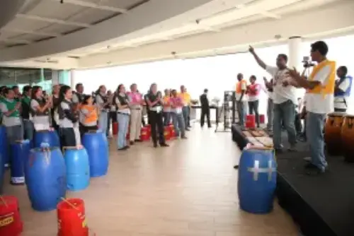 This picture shows a group of participants and one instructor on a stage on a corporate event for a good cause.