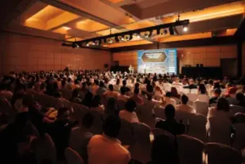 This is a picture of a big crowd in front of a stage. On stage, we created a gameshow with company-specific questions.